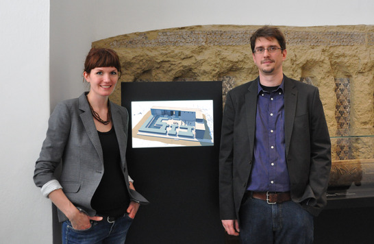 Sandra Grabowski und Sebastian Hageneuer vor der animierten  Rekonstruktion des Steinstift-Gebäudes in Uruk
Quelle: Nina Diezemann